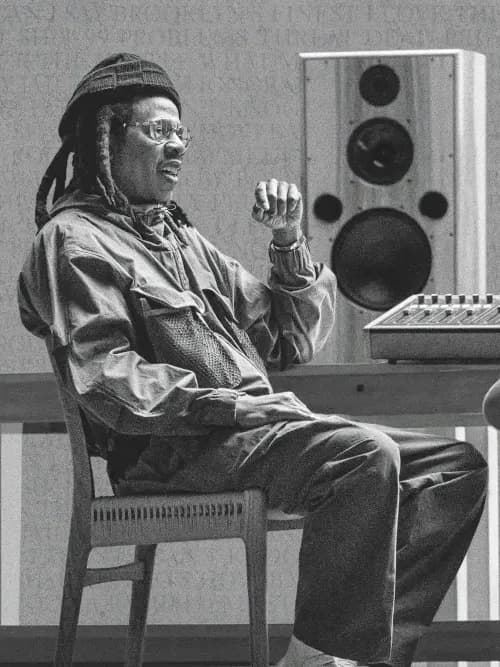 A black-and-white photograph of Jay-Z and Rick Rubin seated across from each other at a mixing desk, mid-conversation