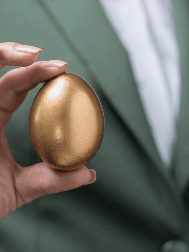 A hand carefully cradles a golden egg, symbolizing a protected nest egg.